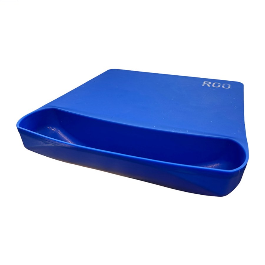 The blue ROO silicone mat gripping a kitchen counter with its scrap pouch over the edge