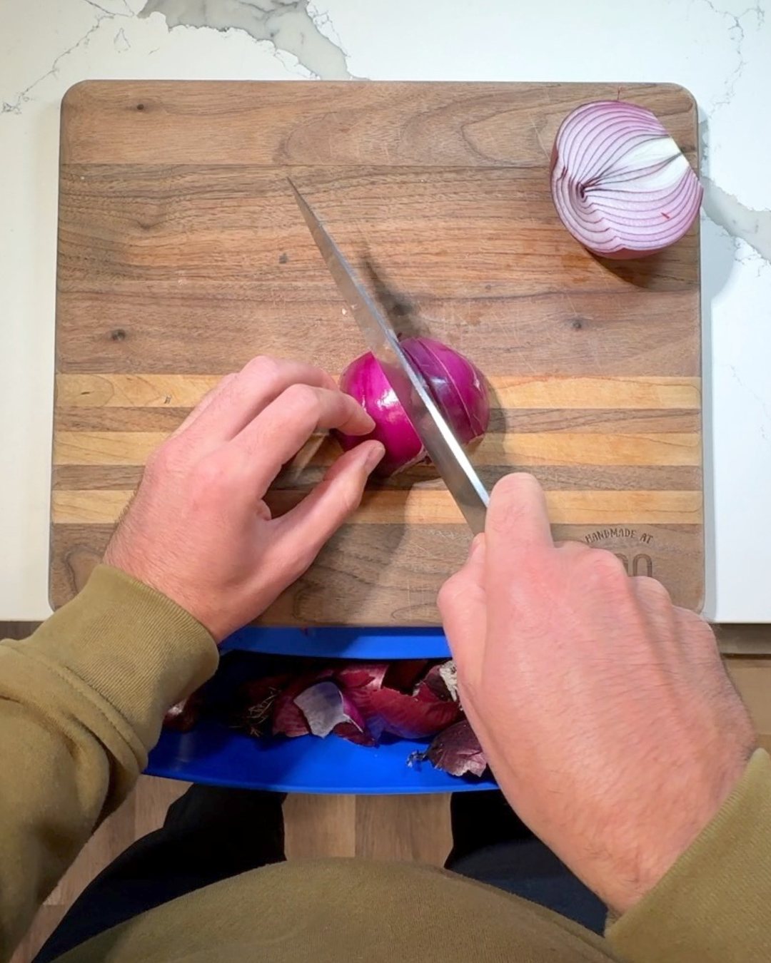 Slicing a red onion on a board resting on the ROO mat, scraps in the pouch